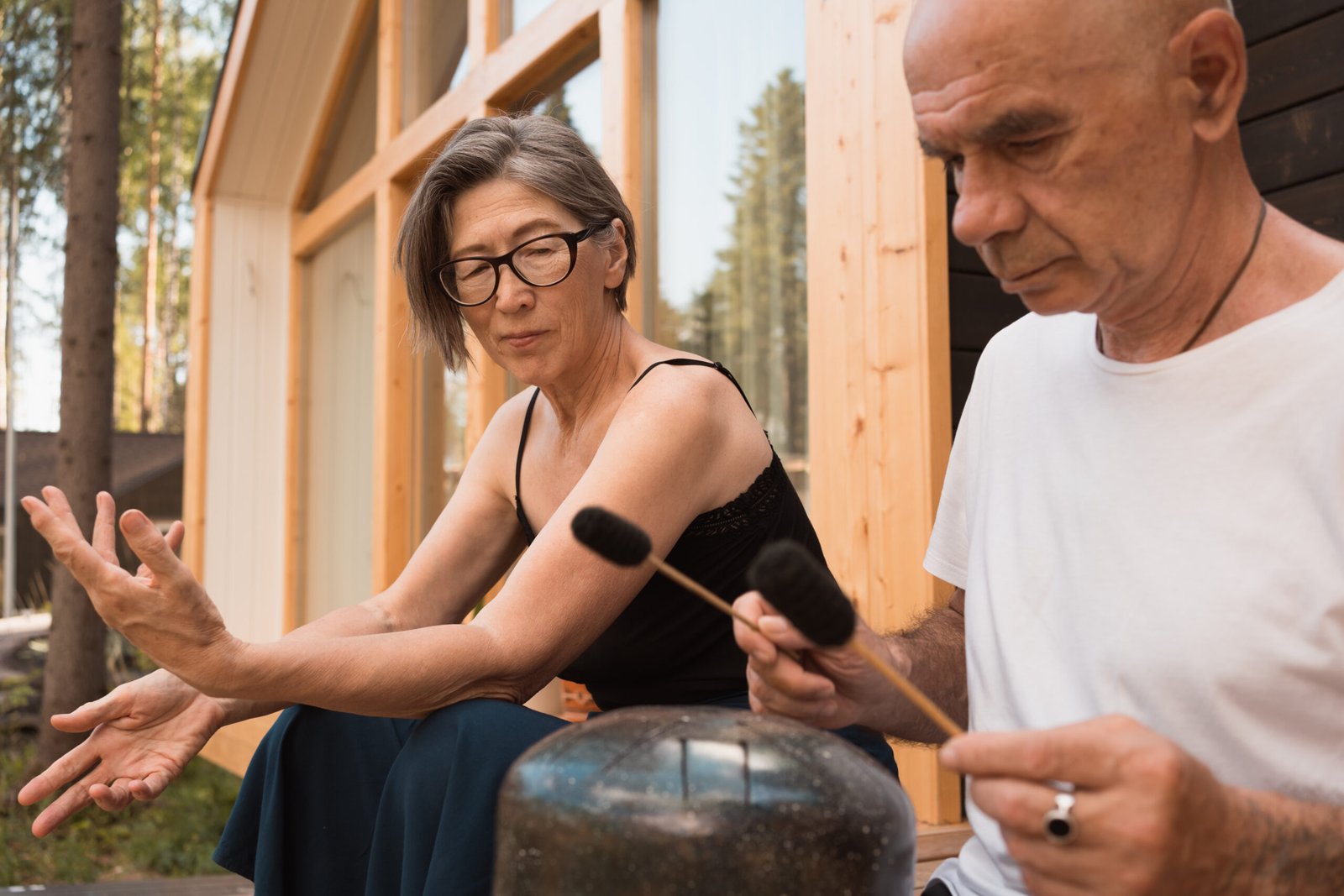 Couple relax with space sounds Senior couple sitting on the terrace at home and playing music on glucophone in summer day